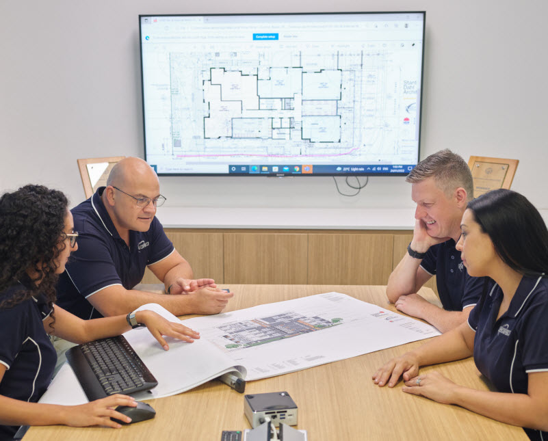 Colleagues discussing the construction plan inside the office