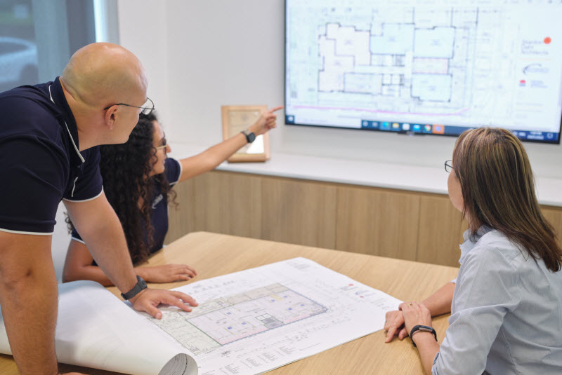 Team discussing a floor plan of a building