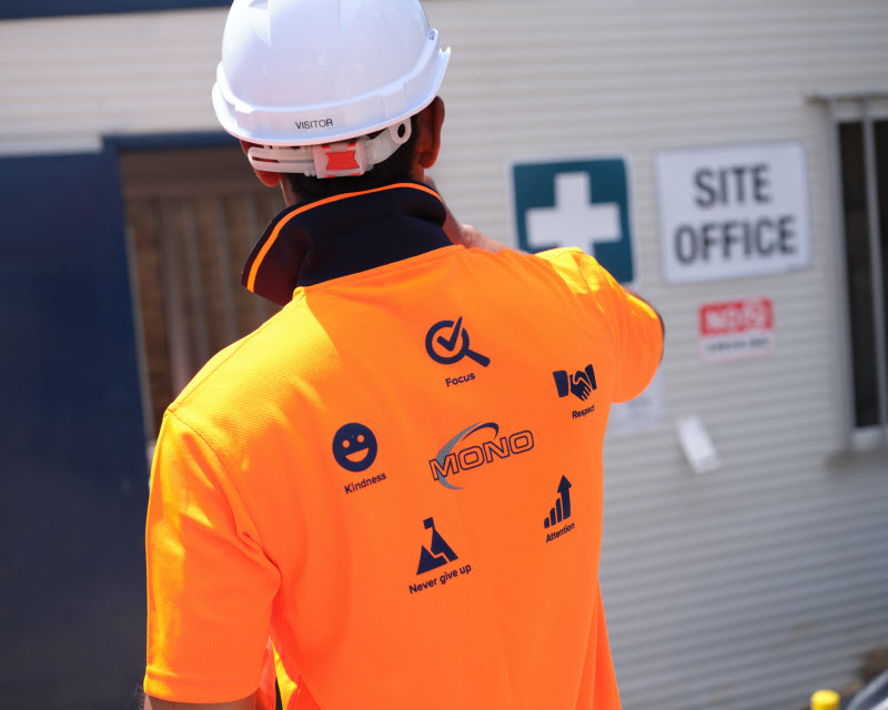 Worker wearing orange uniform with icons at the back